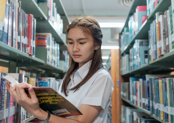 Student reading book in library